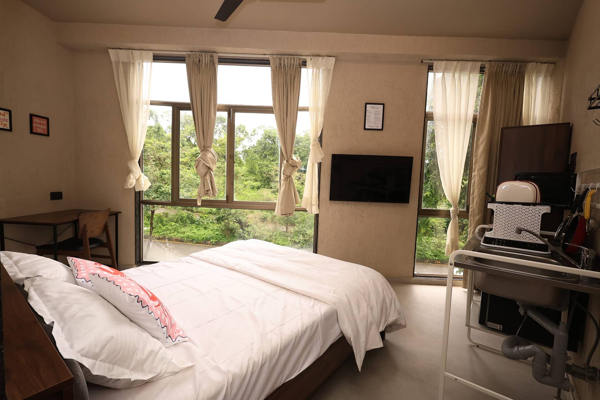 Mikami bedroom with large windows framing greenery