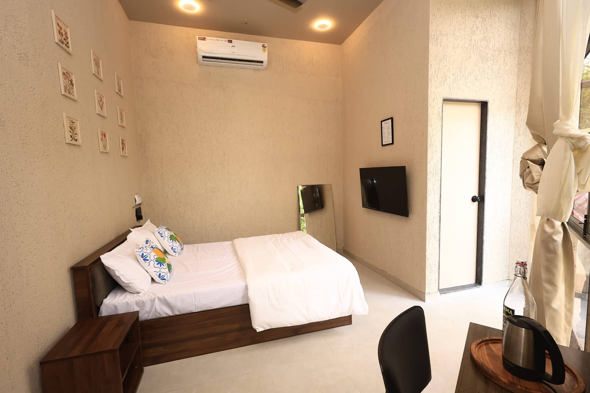 Raku bed facing a wall-mounted TV with botanical artwork