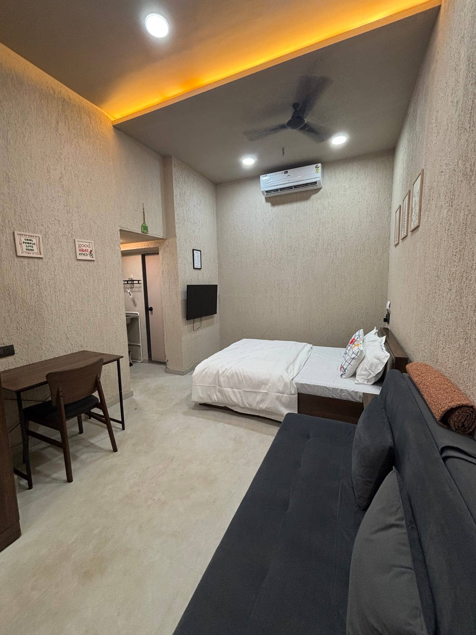 Wide view of Rua with a work desk, bed, sofa and kitchenette