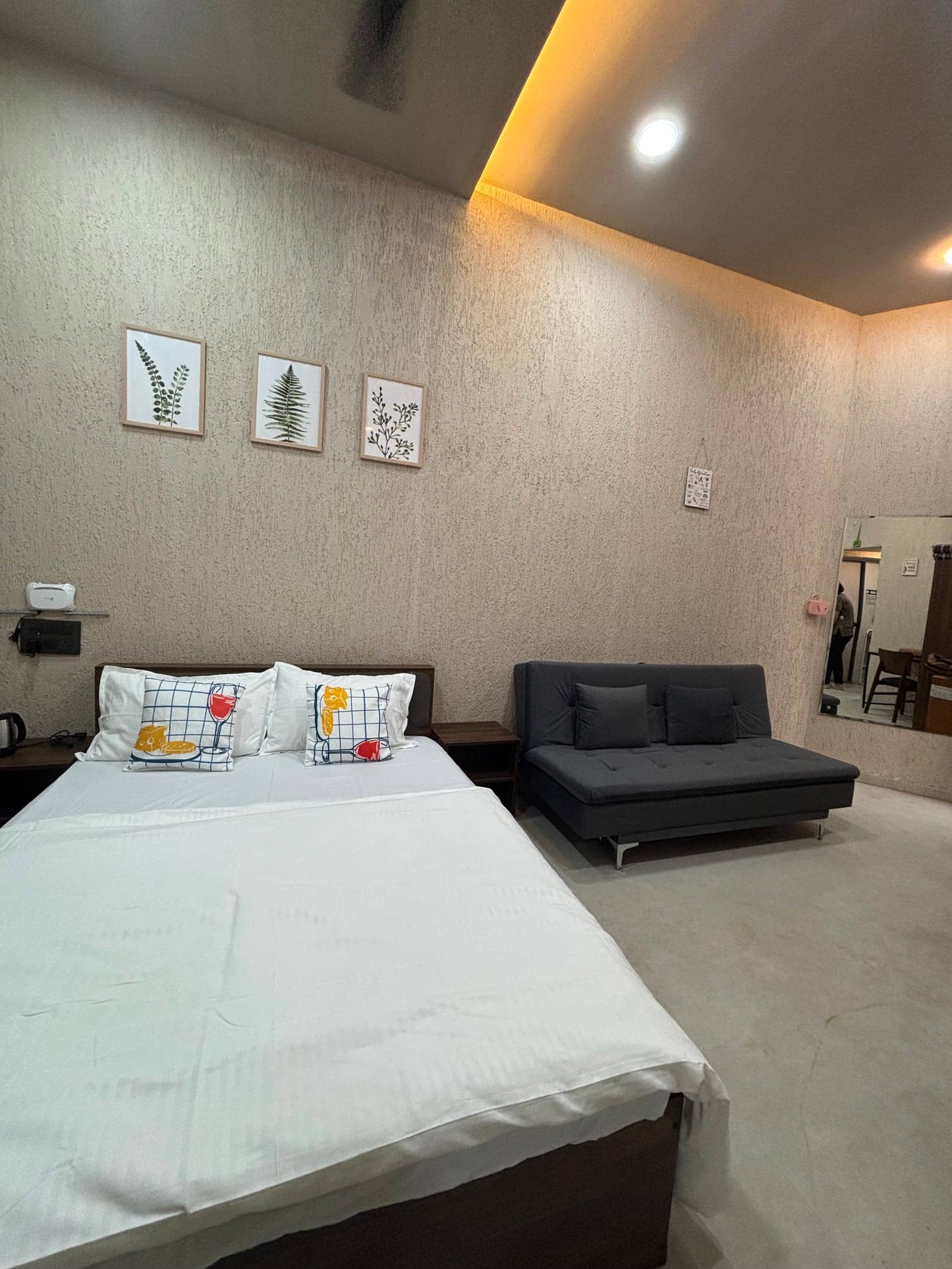 Rua bed beside a grey sofa lounge and full-length mirror
