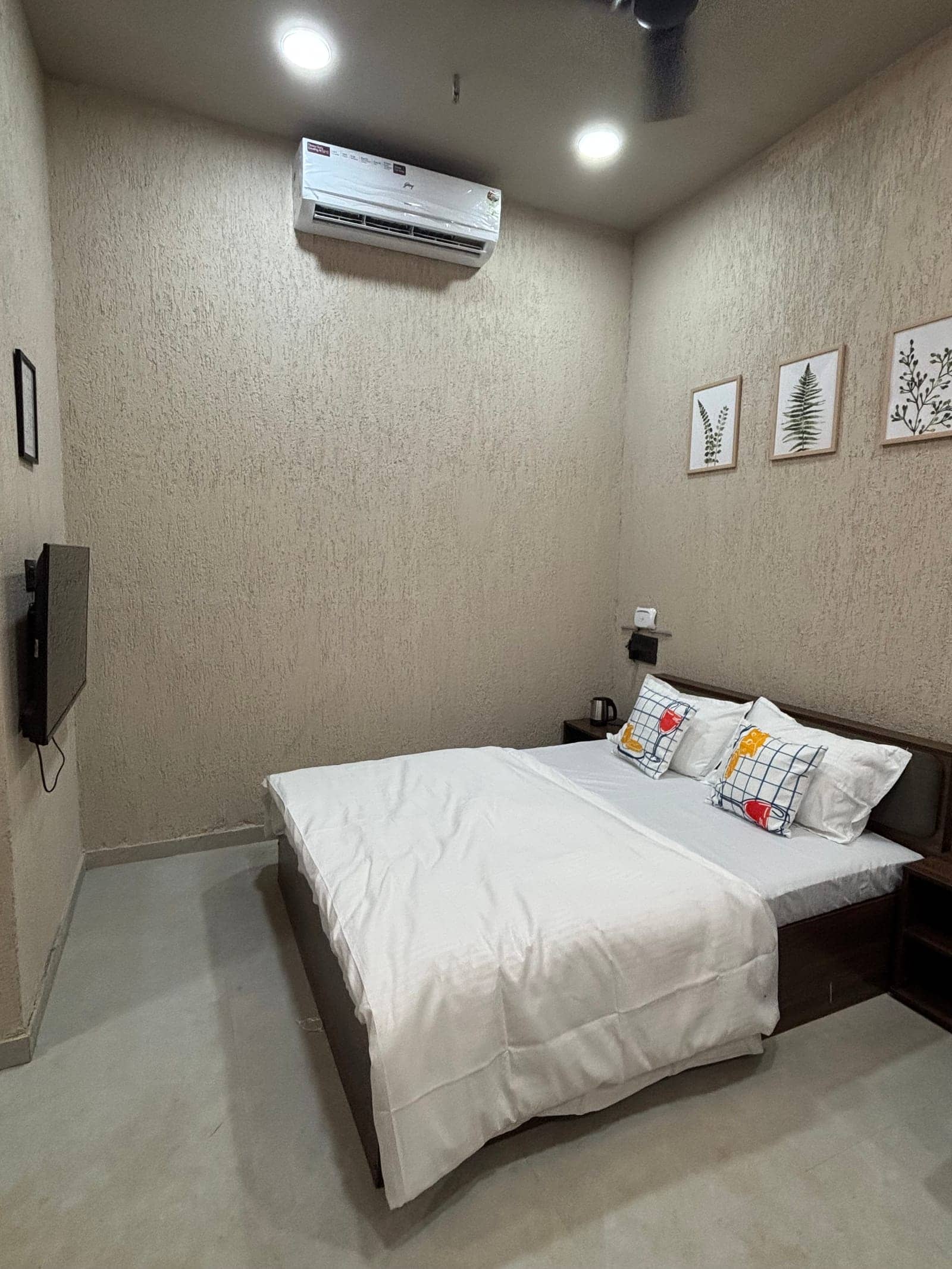 Rua bed with a wall-mounted TV and botanical prints